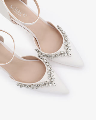 White satin wedding heels with pointed closed toe and starlet rhinestone embellishment, perfect for bridal or formal occasions