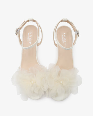 White satin strappy sandals with kitten heels and organza flower details 