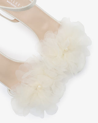 White satin strappy sandals with kitten heels and organza flower details 