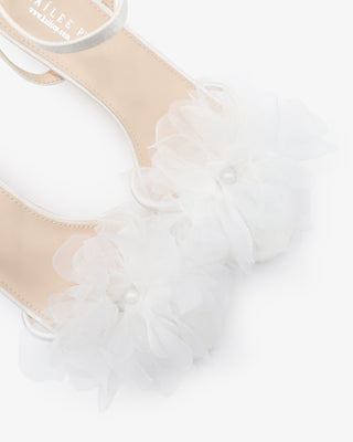 White satin strappy sandals with kitten heels and organza flower details 